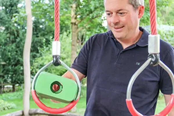 Ludimus Mitarbeiter kontrolliert einen abgehängten Turnring mit einem Prüfkörper auf Fangstellen.