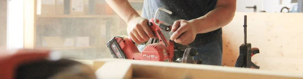 Spielgeräte Herstellung: Detailbild einer Handkreissäge im Einsatz